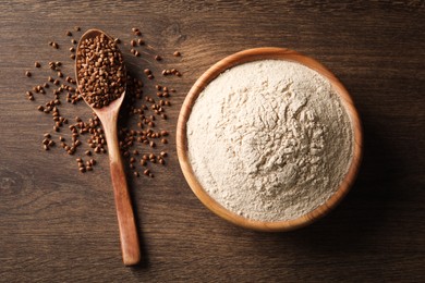 Bowl of flour and spoon with buckwheat on wooden table, flat lay