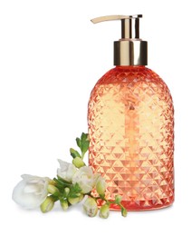 Stylish dispenser with liquid soap and flowers on white background