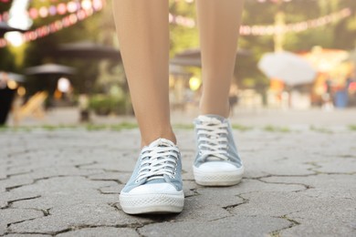 Photo of Woman in stylish shoes walking on city street, closeup