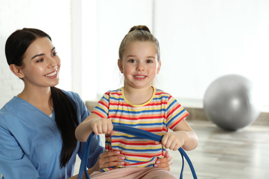 Orthopedist working with little girl in hospital gym
