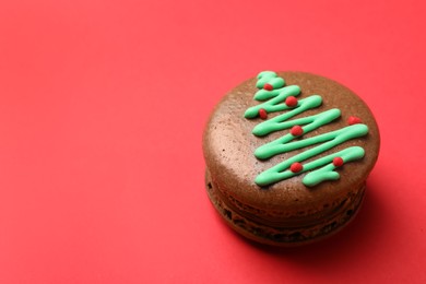 Photo of Beautifully decorated Christmas macaron on red background, space for text