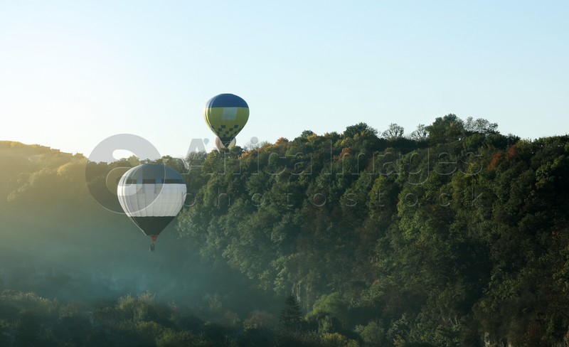 Beautiful view of hot air balloons flying over autumn forest