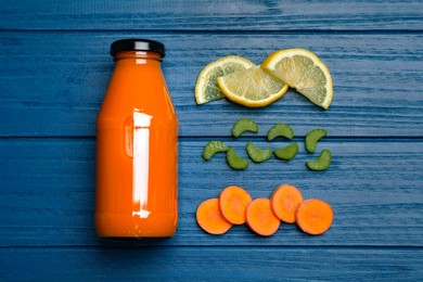 Healthy carrot juice in bottle and ingredients on blue wooden table, flat lay