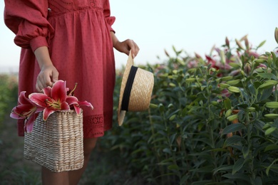 Photo of Young woman in beautiful lily field, closeup. Space for text