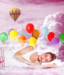 Sweet dreams. Pink cloudy sky with bright air balloons around sleeping young woman