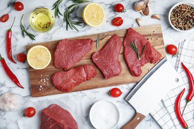 Fresh raw meat steaks and spices on white marble table, flat lay