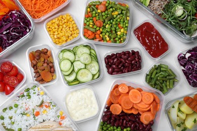 Set of containers with fresh food on white table, flat lay