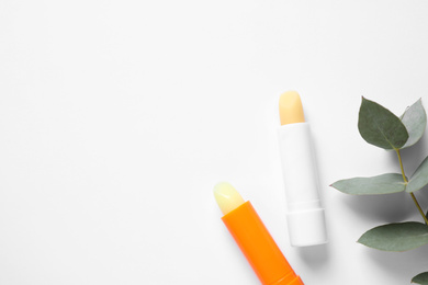 Hygienic lipsticks on white background, top view