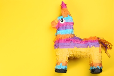 Photo of Bright donkey pinata on yellow background, top view. Space for text