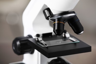 Photo of Modern medical microscope with glass slide on blurred background, closeup. Laboratory equipment