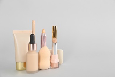 Photo of Foundation makeup products on light background, space for text. Decorative cosmetics