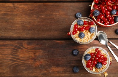Delicious yogurt parfait with fresh berries on wooden table, flat lay. Space for text