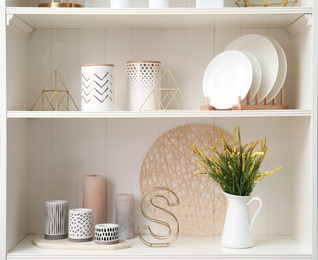 White shelving unit with dishes and different decorative stuff
