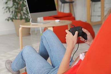 Young woman playing video games at home, closeup