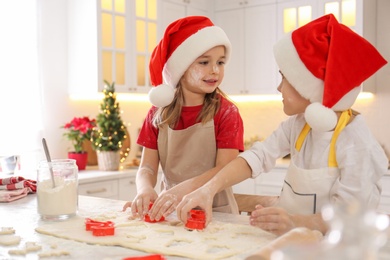 Cute little children making Christmas cookies in kitchen
