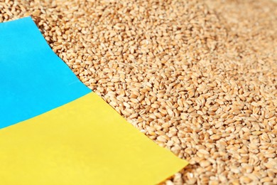 National flag of Ukraine on wheat grains, closeup. Global food crisis concept