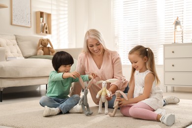 Photo of Happy grandmother and her grandchildren spending time together at home