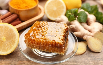 Fresh honeycomb and other products on wooden table, closeup. Natural antibiotics