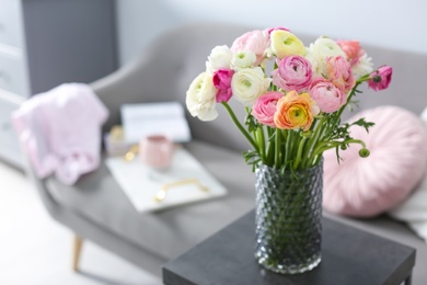 Bouquet of beautiful ranunculuses on table in living room. Space for text