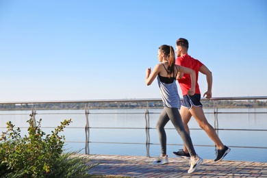 Sporty couple running outdoors on sunny morning
