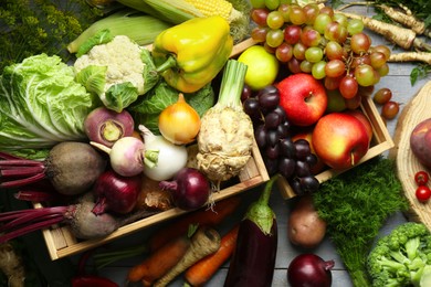 Photo of Different fresh vegetables and fruits on grey wooden table, flat lay. Farmer harvesting