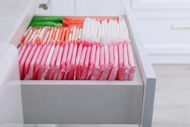 Storage of different feminine hygiene products in drawer indoors