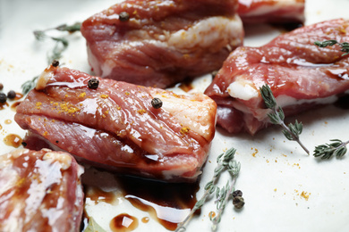 Raw marinated ribs with thyme and peppercorn, closeup