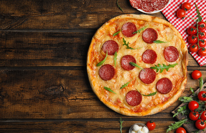 Flat lay composition with tasty pepperoni pizza on wooden table. Space for text