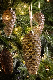 Photo of Christmas tree decorated with holiday baubles and fairy lights, closeup