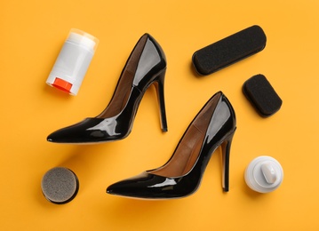 Flat lay composition with shoe care accessories and footwear on yellow background