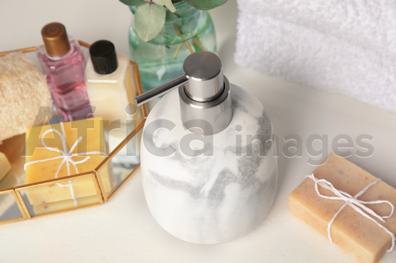 Marble soap dispenser and toiletries on white table