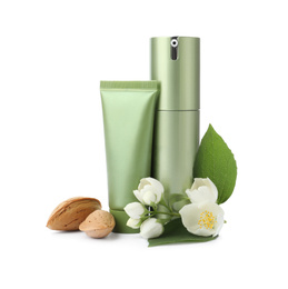 Cosmetic products, almond nuts and flowers on white background