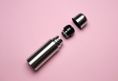 Stainless steel thermos on pink background, top view