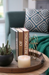 Books with phrase Culture of Belonging on wooden table in room