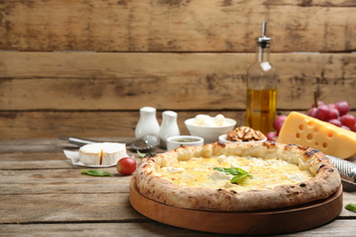 Photo of Delicious cheese pizza on wooden table. Space for text