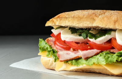 Delicious sandwich with fresh vegetables and mozzarella on grey table, closeup