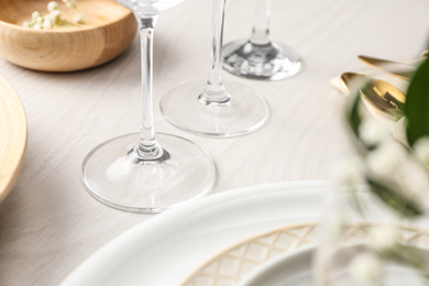 Photo of Glasses on white wooden table, closeup. Festive setting