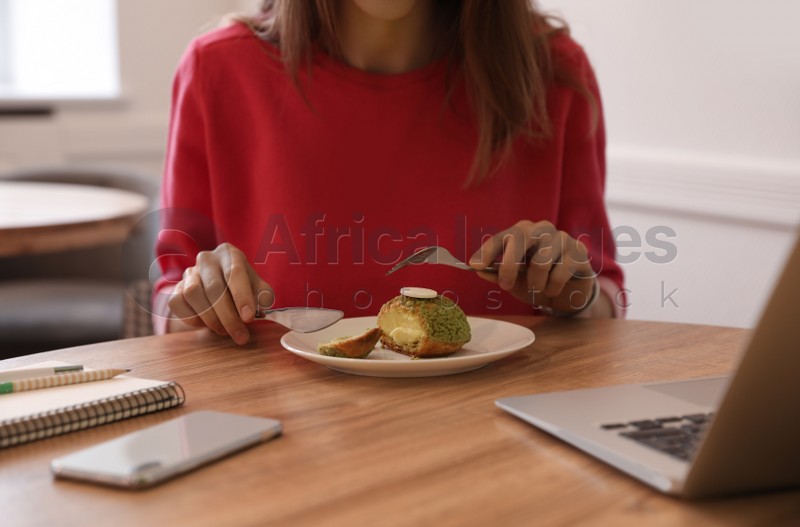 Young blogger eating dessert in cafe, closeup