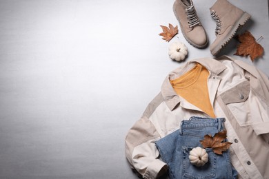 Fall fashion. Layout of women's outfit on light grey background, top view. Space for text