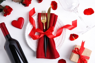 Beautiful place setting for romantic dinner on white wooden table, flat lay. Valentine's day celebration