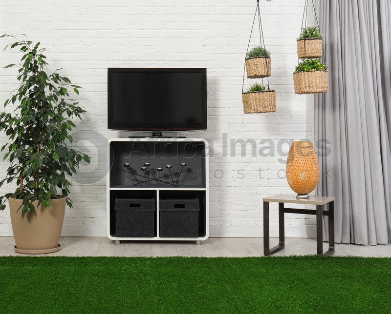 Photo of Living room interior with plasma TV near light wall