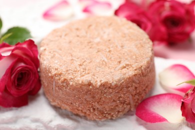 Photo of Solid shampoo bar and roses on table, closeup. Hair care
