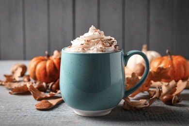 Delicious pumpkin latte on grey wooden table, closeup