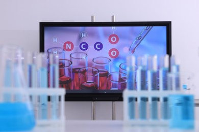Modern interactive board and laboratory glassware in classroom