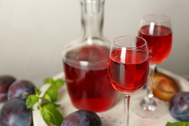 Delicious plum liquor served on tray, closeup. Homemade strong alcoholic beverage