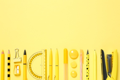 Photo of Flat lay composition with different school stationery on yellow background, space for text