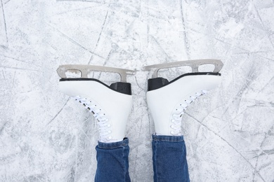 Woman wearing figure skates on ice rink, top view