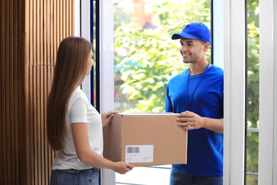 Woman receiving parcel from courier on doorstep