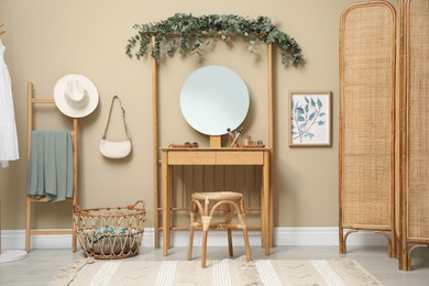 Photo of Stylish room decorated with beautiful eucalyptus garland on dressing table