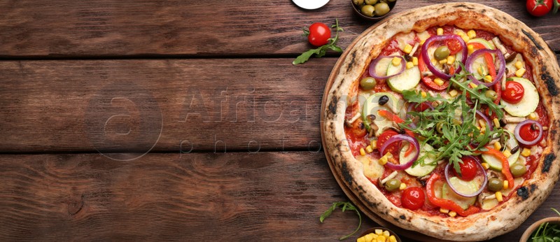 Image of Top view of hot delicious pizza on wooden table, space for text. Banner design 